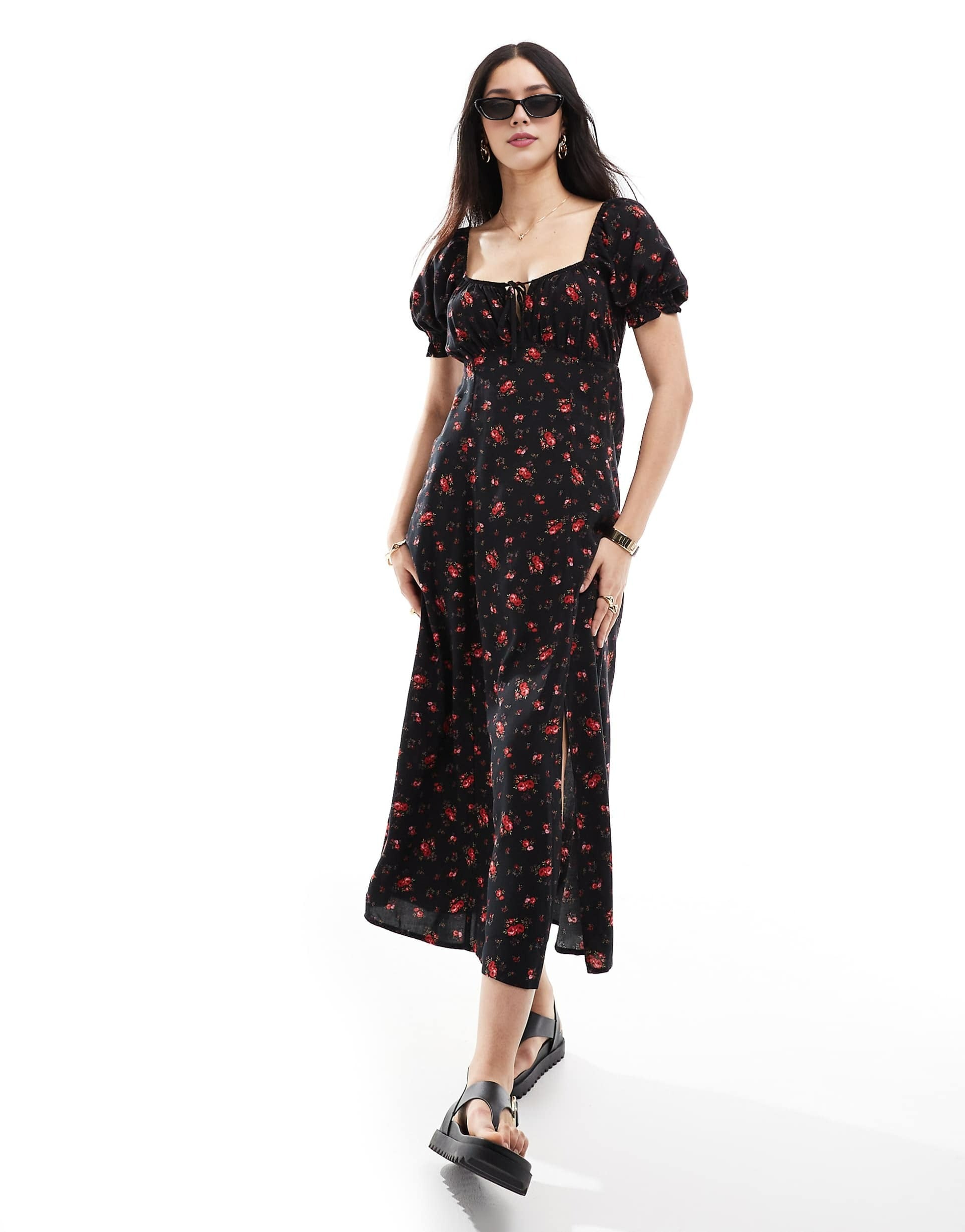 Woman wearing a black floral dress on a white background