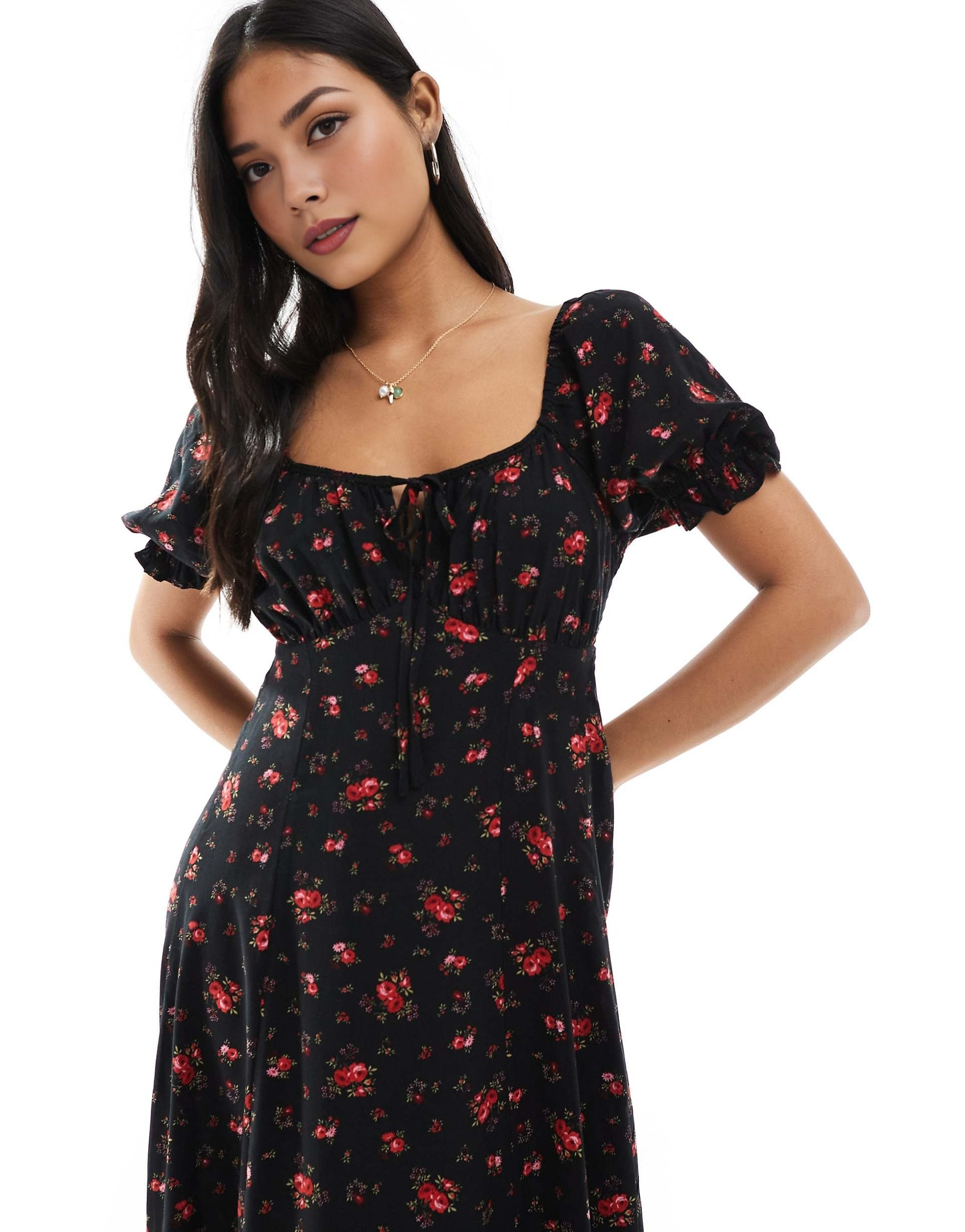 Woman wearing a black floral dress on a white background. date dress, beach dress